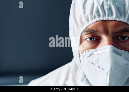 Erschöpfter Arzt in PSA Anzug Uniform in Stress auf schwarz Hintergrund Stockfoto