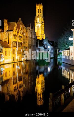 Historisches Stadtzentrum in Brügge bei Nacht, Belgien. Weihnachtliche festliche Dekoration. Alte mittelalterliche Gebäude spiegeln sich im Wasser. Zauberhafte Winterzeit. Stockfoto