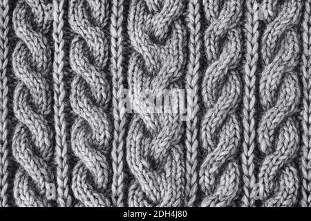 Graue Strickstruktur. Handgefertigte Strickmode. Hintergrund. Farbe von 2021. Handgefertigte Strickmode. Strukturierter Hintergrund. Stockfoto