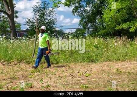Flint, Michigan - Arbeiter von der Michigan Grounds Crew beteiligen sich an einer Gemeinschaft Säuberung von leerstehenden Flächen. Stockfoto