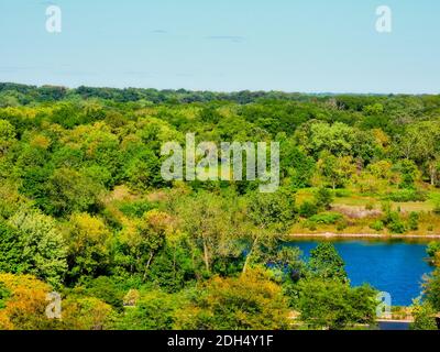 Sommer See und Waldlandschaft Blick: Atemberaubende blauen See von lebendigen grünen Wald von grünen Bäumen an einem Sommertag mit blauem Himmel in landschaftlich umgeben Stockfoto
