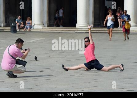 KEINE WEB/KEINE APPS - Asiatische Touristen am 12. August 2017 auf dem Markusplatz, dem Zentrum der touristischen Schwerkraft in Venedig, Italien. Die Stadt Venedig, die von Touristen überfallen wird, riskiert, ‘D„Inselland am Meer“ zu werden. Die meisten Venezianer verachten die giganten Kreuzfahrtschiffe, die jeden Tag durch den Giudecca-Kanal schaufeln, Dämpfe aussenden, die zu Erosion des Watts und Sedimentverlust führen, bevor sie Tausende von Menschen in das historische Zentrum verschleppen. Ob durch Selfie-Stöcke, laute Wheelie-Koffer oder Leute, die auf einer der 391 Brücken schnüffeln, Venedigs Verachtung gegenüber den 30 Millionen Besuchern, die flo irritiert Stockfoto