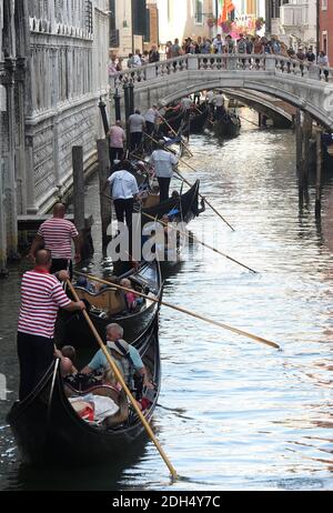 KEINE WEB/KEINE APPS - Stau der Gondeln in Venedig, Italien am 12. August 2017. Die Stadt Venedig, die von Touristen überfallen wird, riskiert, ‘D„Inselland am Meer“ zu werden. Die meisten Venezianer verachten die giganten Kreuzfahrtschiffe, die jeden Tag durch den Giudecca-Kanal schaufeln, Dämpfe aussenden, die zu Erosion des Watts und Sedimentverlust führen, bevor sie Tausende von Menschen in das historische Zentrum verschleppen. Ob durch Selfie-Stöcke, laute Wheelie-Koffer oder Leute, die auf einer der 391 Brücken schnüffeln, die Verachtung der Venezianer gegenüber den 30 Millionen Besuchern, die die Stadt jedes Jahr überschwemmen, ist alarmierend Stockfoto