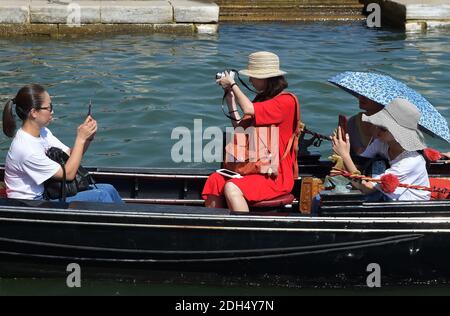 KEINE WEB/KEINE APPS - Asiatische Touristen in einer Gondel in Venedig, Italien am 12. August 2017. Die Stadt Venedig, die von Touristen überfallen wird, riskiert, ‘D„Inselland am Meer“ zu werden. Die meisten Venezianer verachten die giganten Kreuzfahrtschiffe, die jeden Tag durch den Giudecca-Kanal schaufeln, Dämpfe aussenden, die zu Erosion des Watts und Sedimentverlust führen, bevor sie Tausende von Menschen in das historische Zentrum verschleppen. Ob durch Selfie-Stöcke, laute Wheelie-Koffer oder Leute, die auf einer der 391 Brücken schnüffeln, die Verachtung der Venezianer gegenüber den 30 Millionen Besuchern, die die Stadt jedes Jahr überschwemmen, hat einen starken Höhepunkt erreicht Stockfoto