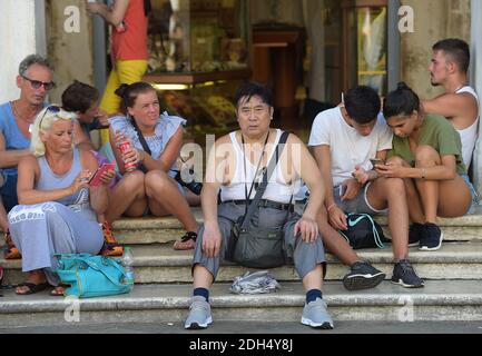 KEINE WEB/KEINE APPS - Touristen auf dem Markusplatz, dem Zentrum der touristischen Schwerkraft in Venedig, Italien am 12. August 2017. Hier ist es verboten zu sitzen. Die Stadt Venedig, die von Touristen überfallen wird, riskiert, ‘D„Inselland am Meer“ zu werden. Die meisten Venezianer verachten die giganten Kreuzfahrtschiffe, die jeden Tag durch den Giudecca-Kanal schaufeln, Dämpfe aussenden, die zu Erosion des Watts und Sedimentverlust führen, bevor sie Tausende von Menschen in das historische Zentrum verschleppen. Ob durch Selfie-Stöcke, laute Wheelie-Koffer oder Leute, die auf einer der 391 Brücken schnüffeln, Venedigs Verachtung gegenüber den 30 m genervt Stockfoto