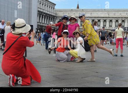 KEINE WEB/KEINE APPS - Asiatische Touristen am 12. August 2017 auf dem Markusplatz, dem Zentrum der touristischen Schwerkraft in Venedig, Italien. Die Stadt Venedig, die von Touristen überfallen wird, riskiert, ‘D„Inselland am Meer“ zu werden. Die meisten Venezianer verachten die giganten Kreuzfahrtschiffe, die jeden Tag durch den Giudecca-Kanal schaufeln, Dämpfe aussenden, die zu Erosion des Watts und Sedimentverlust führen, bevor sie Tausende von Menschen in das historische Zentrum verschleppen. Ob durch Selfie-Stöcke, laute Wheelie-Koffer oder Leute, die auf einer der 391 Brücken schnüffeln, Venedigs Verachtung gegenüber den 30 Millionen Besuchern, die flo irritiert Stockfoto