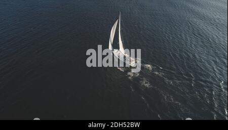 Von oben nach unten auf der Segelyacht. Segelflugboot-Regatta unter Segeln auf offener See. Ruhige Meereslandschaft. Luxusboot bei Sommerkreuzfahrt im Hafen von Brodick, Arran Island, Schottland, Europa Stockfoto