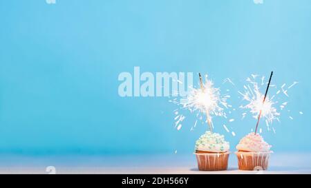 Zwei Cupcakes mit Wunderkerzen verziert, kopieren Raum Stockfoto