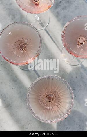 Gläser mit kaltrosa Champagner auf dem Tisch platziert Stockfoto