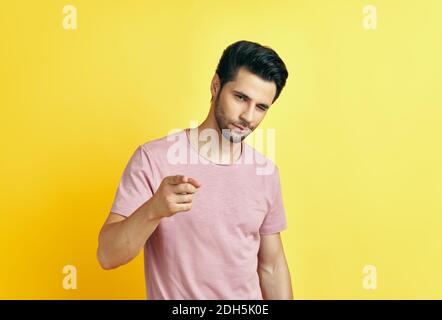 Hübscher junger Mann, der auf Sie zeigt und auf gelben Hintergrund zur Kamera schaut. Stockfoto