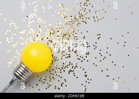 Eine gelbe dekorative Lampe auf grauem Hintergrund. Stockfoto