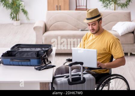 Junger Mann im Rollstuhl bereitet sich auf die Abreise zu Hause vor Stockfoto