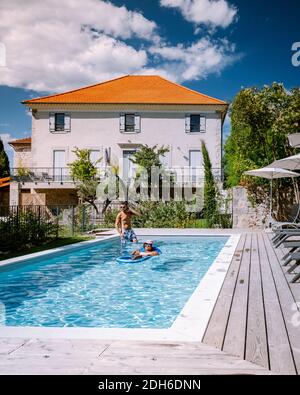 Französisches Ferienhaus mit Holzterrasse und Swimmingpool in der Ardeche Frankreich. Paar entspannen am Pool mit Holzterrasse duri Stockfoto