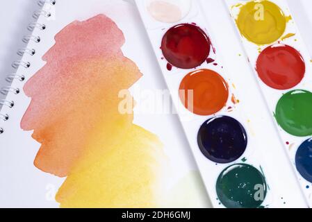 Bunte Aquarell-Pinselstriche, Draufsicht der Pinsel-Palette und Aquarell-Farben mit weißem Papier Stockfoto