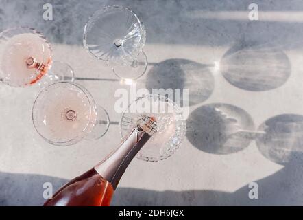 Gläser mit kaltrosa Champagner auf dem Tisch platziert Stockfoto