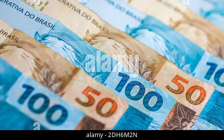 Eine Nahaufnahme der brasilianischen 100 und 50 Reais Banknoten Hintergrund Stockfoto