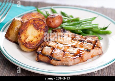 Bio Schweinefleisch mit Pan sautierten Kartoffeln und grüne Bohnen mit einem Pfirsich Sauce chop Stockfoto