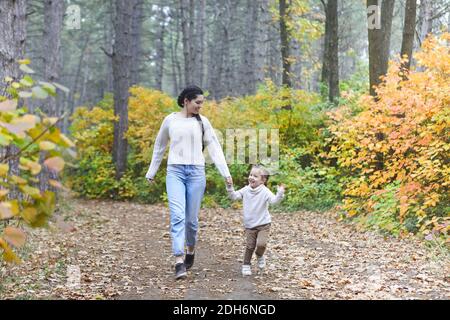 Mutter und Tochter spielen im Herbstpark. Eltern und Kinder wandern an einem Herbsttag im Wald Stockfoto