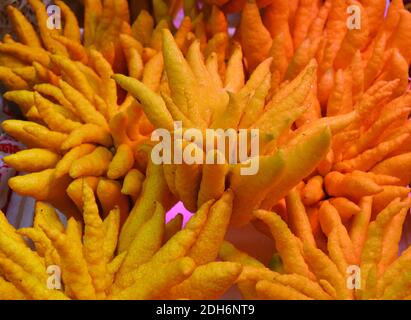 Frisch gefingerte Zitrone am Stand zum Verkauf unter Orange Leicht Stockfoto