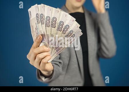 Frau hält russisches Geld vor sich. Nahaufnahme des Rubels, selektiver Fokus. Stockfoto
