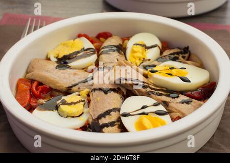 Eine Schüssel Salat mit geröstetem Paprika, Thunfischbauch und gekochtem Ei Stockfoto
