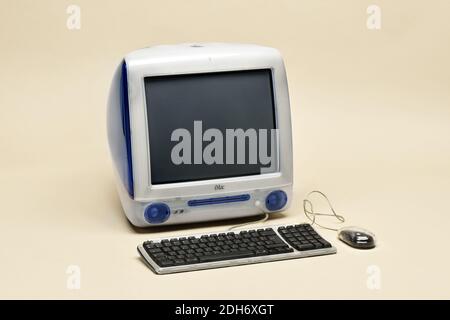Apple iMac G3 Computer von 1998 in original Indigo blau Farbe. Retro-Computer mit Tastatur und Maus auf beigem Hintergrund isoliert Stockfoto