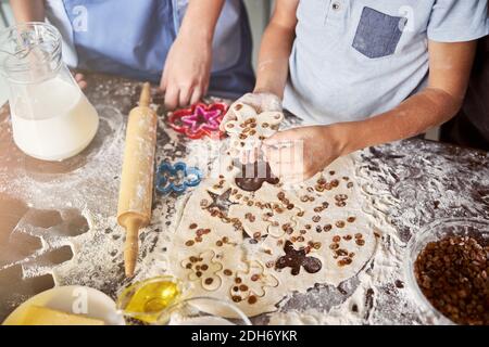 Kleine Bäcker schnitzten aus Teig menschengeformte Kekse Stockfoto