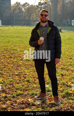 Porträt eines schönen jungen Mannes im Park - Herbstlandschaft Stockfoto