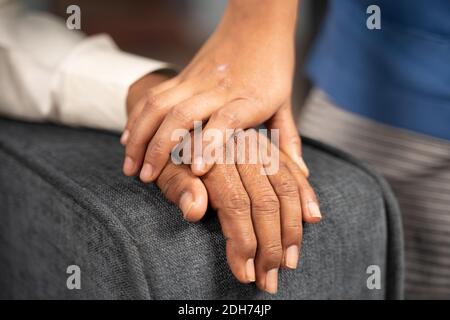 Nahaufnahme der Hände des Arztes, der die Hand eines älteren Bürgers mit Beileid hält - Konzept der Philanthropie, des Pflegepersonals und der Freundlichkeit gegenüber älteren Menschen Stockfoto