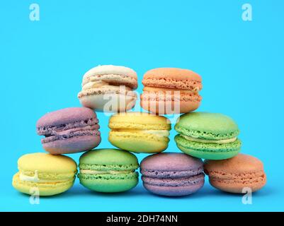 Mehrfarbige runde gebackene Macarons Kuchen auf hellblauem Hintergrund Stockfoto