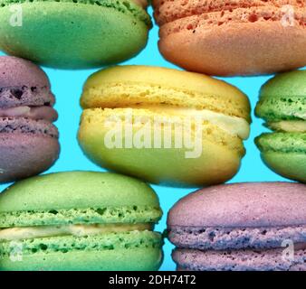 Mehrfarbige runde gebackene Macarons Kuchen auf hellblauem Hintergrund Stockfoto