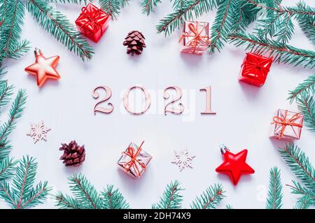 Neujahr 2021 Hintergrund mit 2021 Figuren, Weihnachtsspielzeug, Tannenzweigen. Flachlage, Draufsicht auf die Komposition des neuen Jahres 2021 Stockfoto