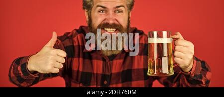 Toasting und jubelnden Aperitif. Freizeit und Feier. Mann trinkt Bier in der Bar. Bier mit Schaum. Brutal Hipster trinken Bier. Reife bärtige Barkeeper halten Bierglas. Zuversichtlich Barkeeper Anheben Toast. Stockfoto