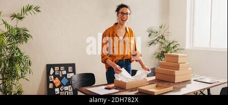 Kleinunternehmen Eigentümer Verpackung einer Box für den Versand an den Online-Client. Weibliche Unternehmerin Vorbereitung des Pakets zur Lieferung. Stockfoto