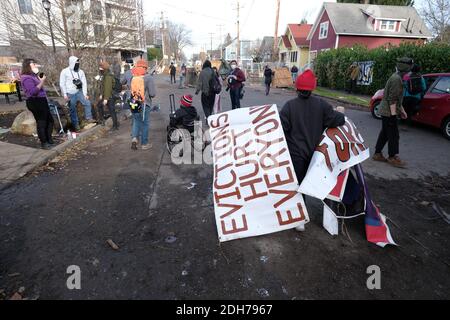 Portland, USA. Dezember 2020. Demonstranten gruppieren sich am 8. Dezember 2020 um das Rote Haus in der Mississippi Street in Portland, Oregon, nach einem Versuch der Polizei, das Grundstück zu vertreiben. Aktivisten zelteten seit September vor dem Haus in der Hoffnung, die dort lebende Familie der Schwarzen und Indigenen zu erhalten, nachdem ein Richter des Landkreises Multnomah die Räumung genehmigt hatte. (Foto: Alex Milan Tracy/Sipa USA) Quelle: SIPA USA/Alamy Live News Stockfoto