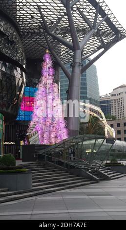 SINGAPUR, SINGAPUR - 11. Nov 2019: Ein elektrischer Weihnachtsbaum in Pink, beleuchtet am Tag vor einer Mall für Top-Marken an der Orchard Road Stockfoto