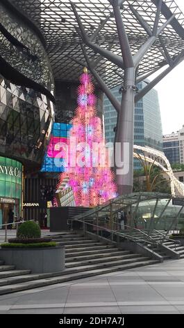 SINGAPUR, SINGAPUR - 11. Nov 2019: Ein elektrischer Weihnachtsbaum in Pink, beleuchtet am Tag vor einer Mall für Top-Marken an der Orchard Road Stockfoto