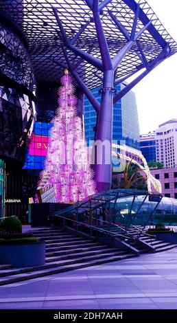 SINGAPUR, SINGAPUR - 11. Nov 2019: Ein elektrischer Weihnachtsbaum in Pink, beleuchtet am Tag vor einer Mall für Top-Marken an der Orchard Road Stockfoto