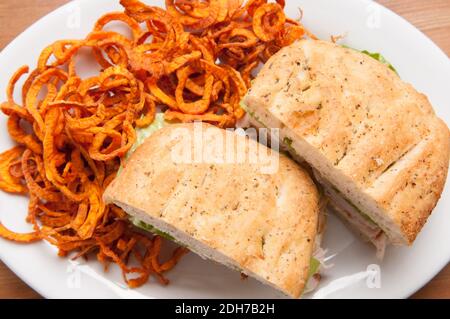 putenfocaccia-Sandwich mit handgemachten frittierten Süßkartoffeln Sprialchips Stockfoto