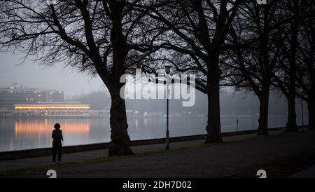 Hannover, Deutschland. Dezember 2020. Eine Frau joggt im Morgengrauen am Maschsee. Kredit: Julian Stratenschulte/dpa/Alamy Live Nachrichten Stockfoto