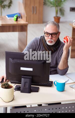 Alter männlicher Angestellter, der während einer Pandemie vom Haus aus arbeitet Stockfoto
