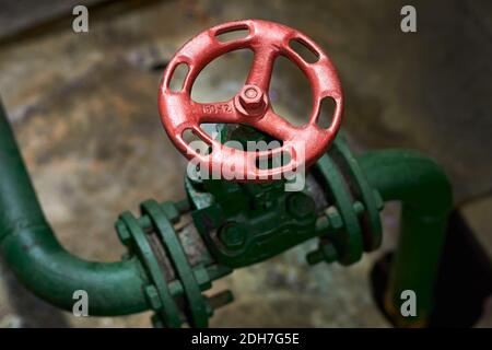 Industrielle chemische petrochemische Retro-Stil grüne Ventil Nahaufnahme mit selektiven Fokus auf rotes Lenkrad mit Flanschanschluss Grün Stockfoto