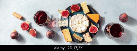 Käsepanorama. Verschiedene Käsesorten mit Wein und Feigen, ein flaches Lay Stockfoto