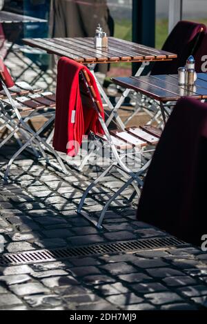 Stühle und Tische mit Decke auf der Restaurantterrasse. Leere Tische mit Stuhl und Decken in einem Restaurant outdoor.chairs mit warmen Decken Stockfoto