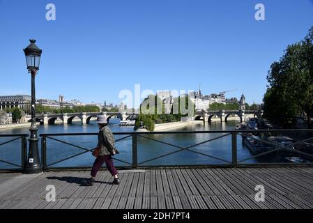 Paris (Frankreich): Natürliche Flussinsel „ile de la Cite“ von der Brücke „Pont des Arts“ aus gesehen. Frau, allein, zu Fuß auf der Brücke "Pont des Arts", und Stockfoto