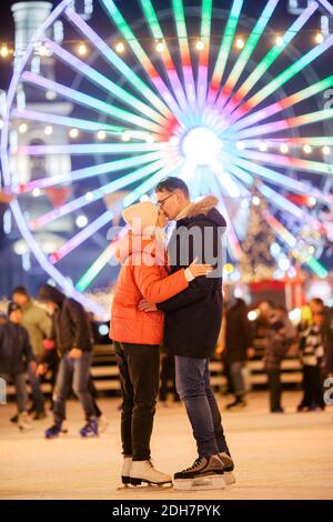 Ein junges kaukasisches Paar verbringt Neujahr und Weihnachten Urlaub in einer aktiven und sportlichen Art und Weise auf die Stadt Eisarena auf der Stockfoto