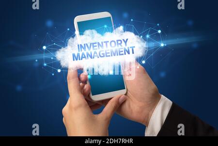 Weibliche Hand berühren Smartphone mit Inventory Management Inschrift, Cloud Business Konzept Stockfoto