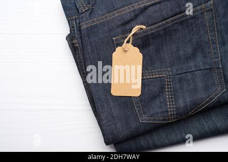 Blank braun rechteckigen Tag in der hinteren Tasche von gebunden Blaue gefaltete Jeans Stockfoto