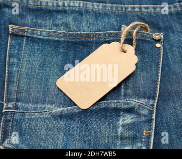 Blank braun rechteckigen Tag in der hinteren Tasche von gebunden Blaue gefaltete Jeans Stockfoto