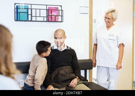 Glückliche Krankenschwester, die mit Patienten im Wartezimmer spricht Orthopädische Klinik Stockfoto